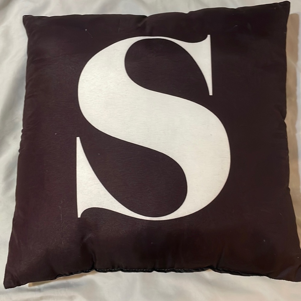 Black throw pillow with letter S on the front